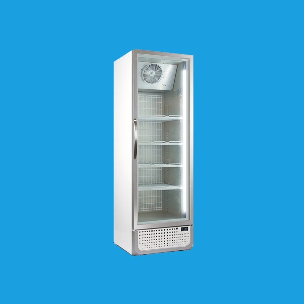 A tall, upright refrigerator with a glass door and several empty shelves stands against a solid blue background. The refrigerator features a fan at the top inside and a vent on the bottom front.