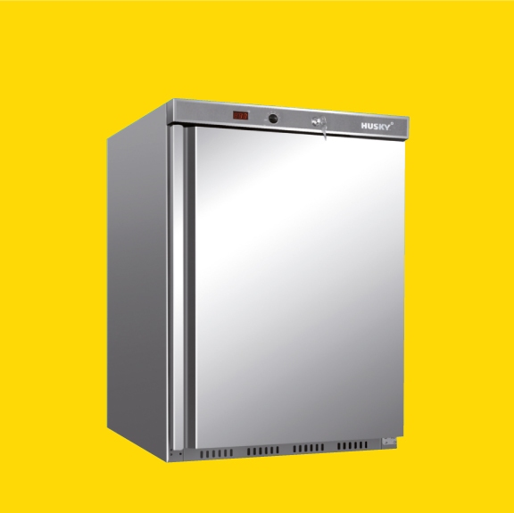 A stainless steel refrigerator with a front door lock and digital display stands against a solid yellow background. The brand name "HUSKY" is visible on the top right corner.